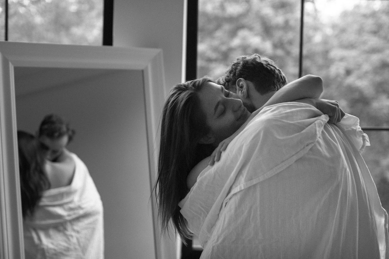 Пара обнимается у зеркала