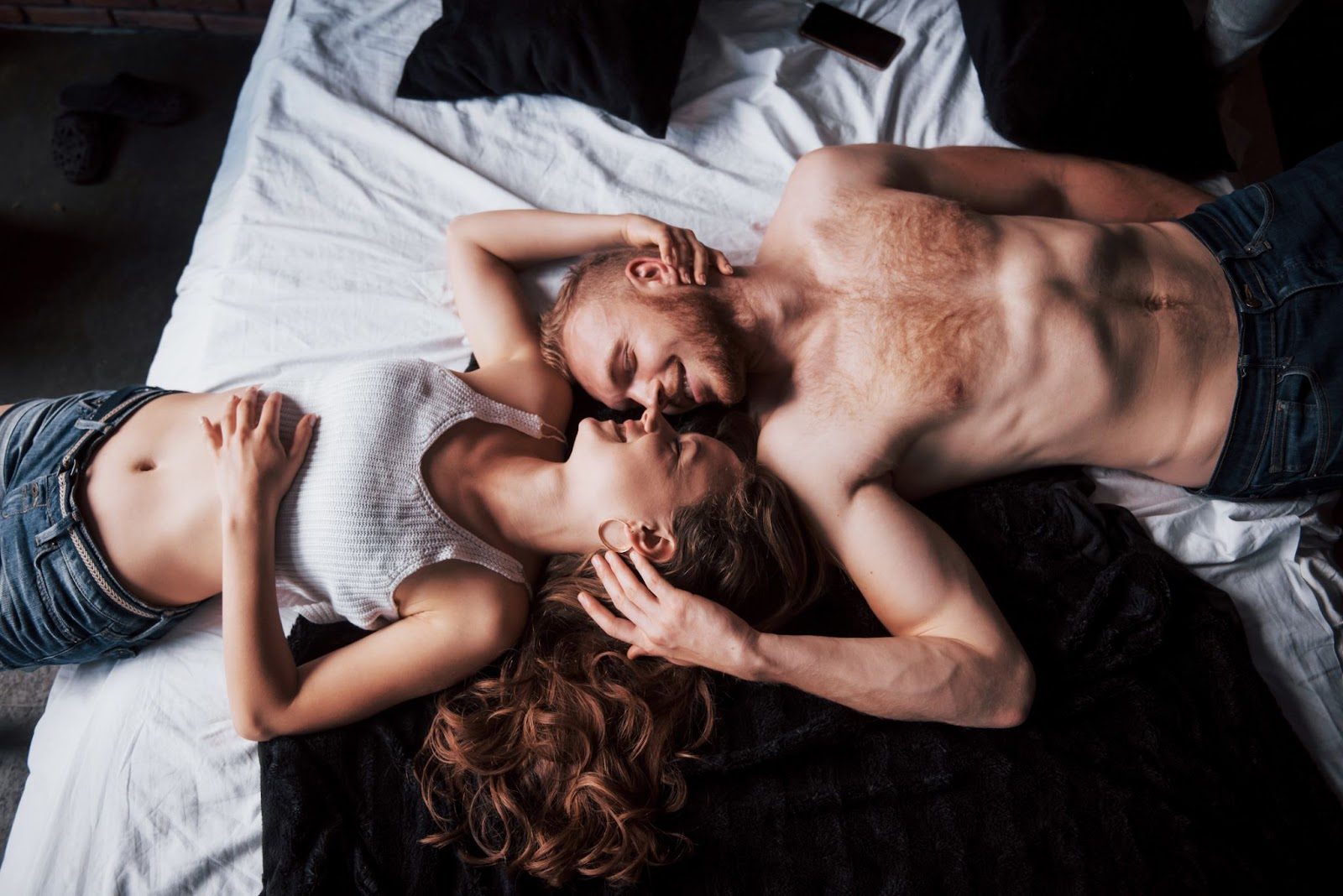 Пара наслаждается объятиями и поцелуями в кровати