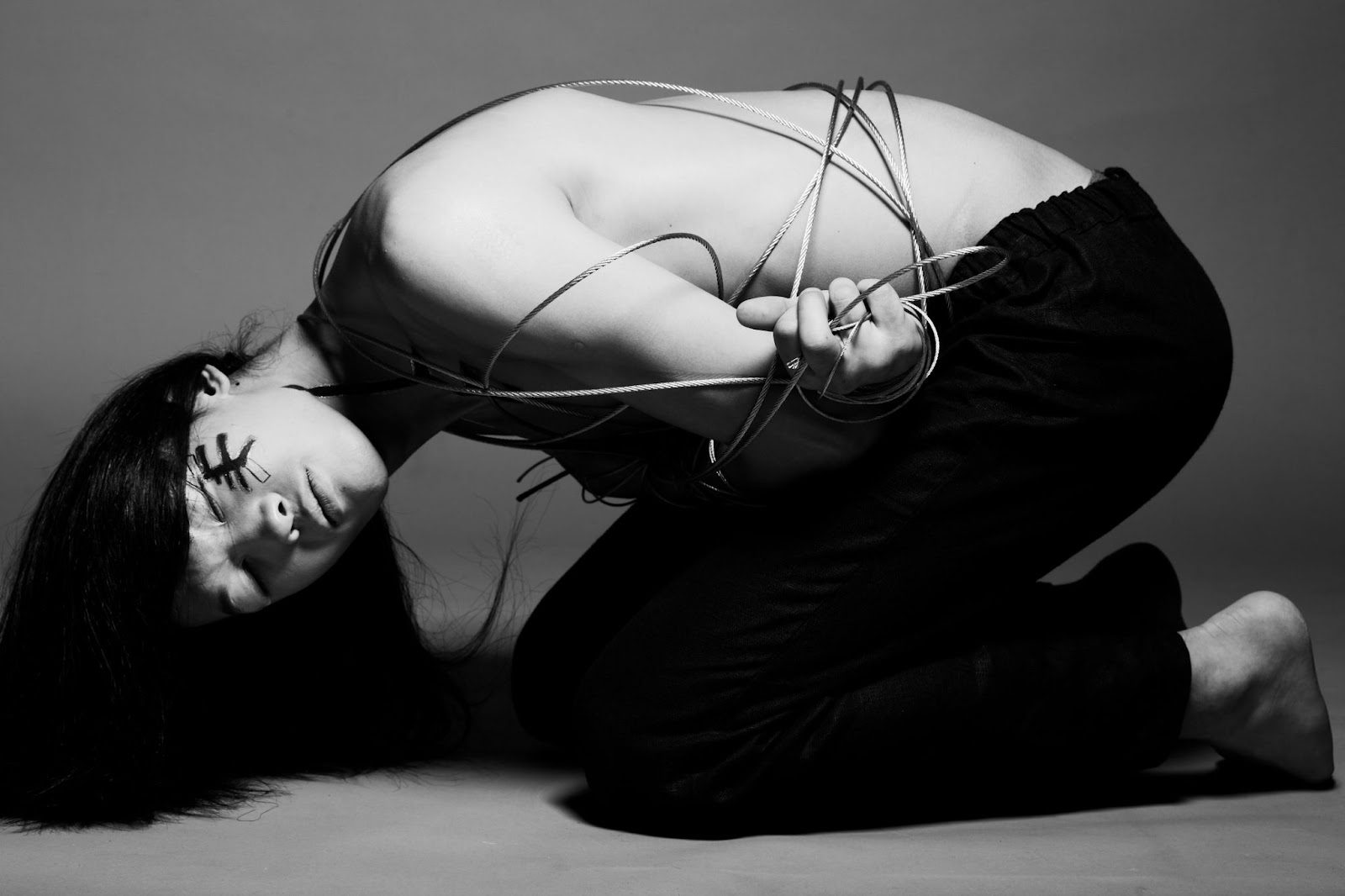 Женщина в красивой обвязке шибари с узором на спине