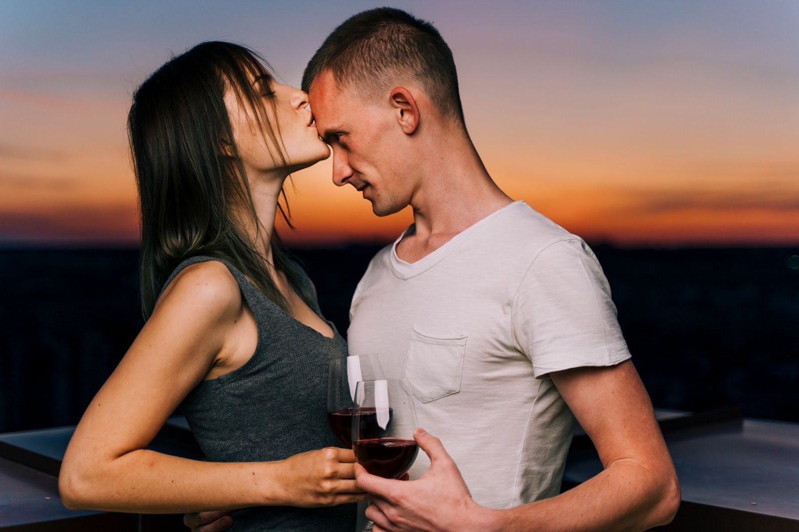 Пара на пляже, держащаяся за руки на закате под пальмами