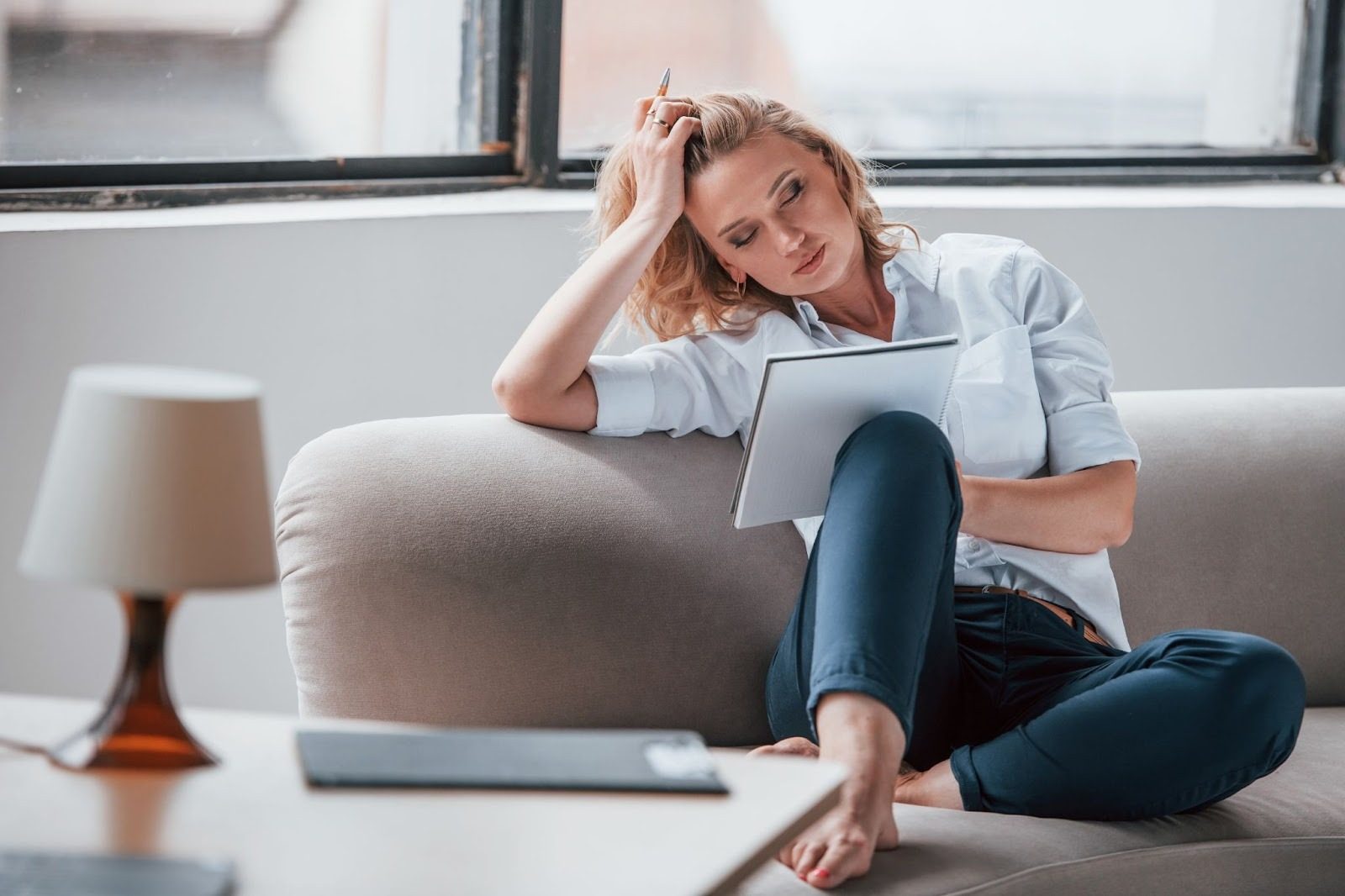 Девушка держится за живот из-за боли и дискомфорта во время секса