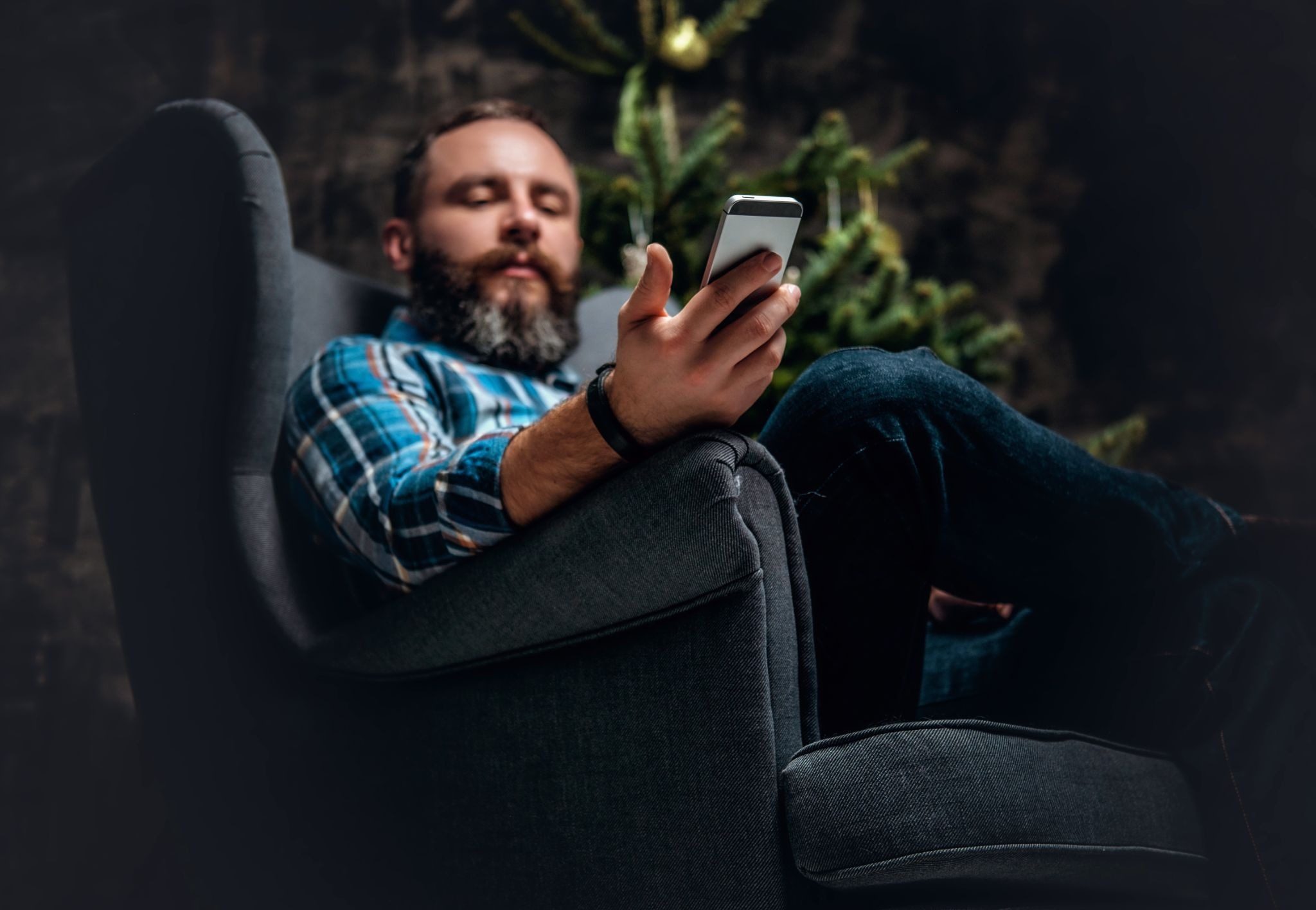 мужчина читает сообщение от девушки и улыбается