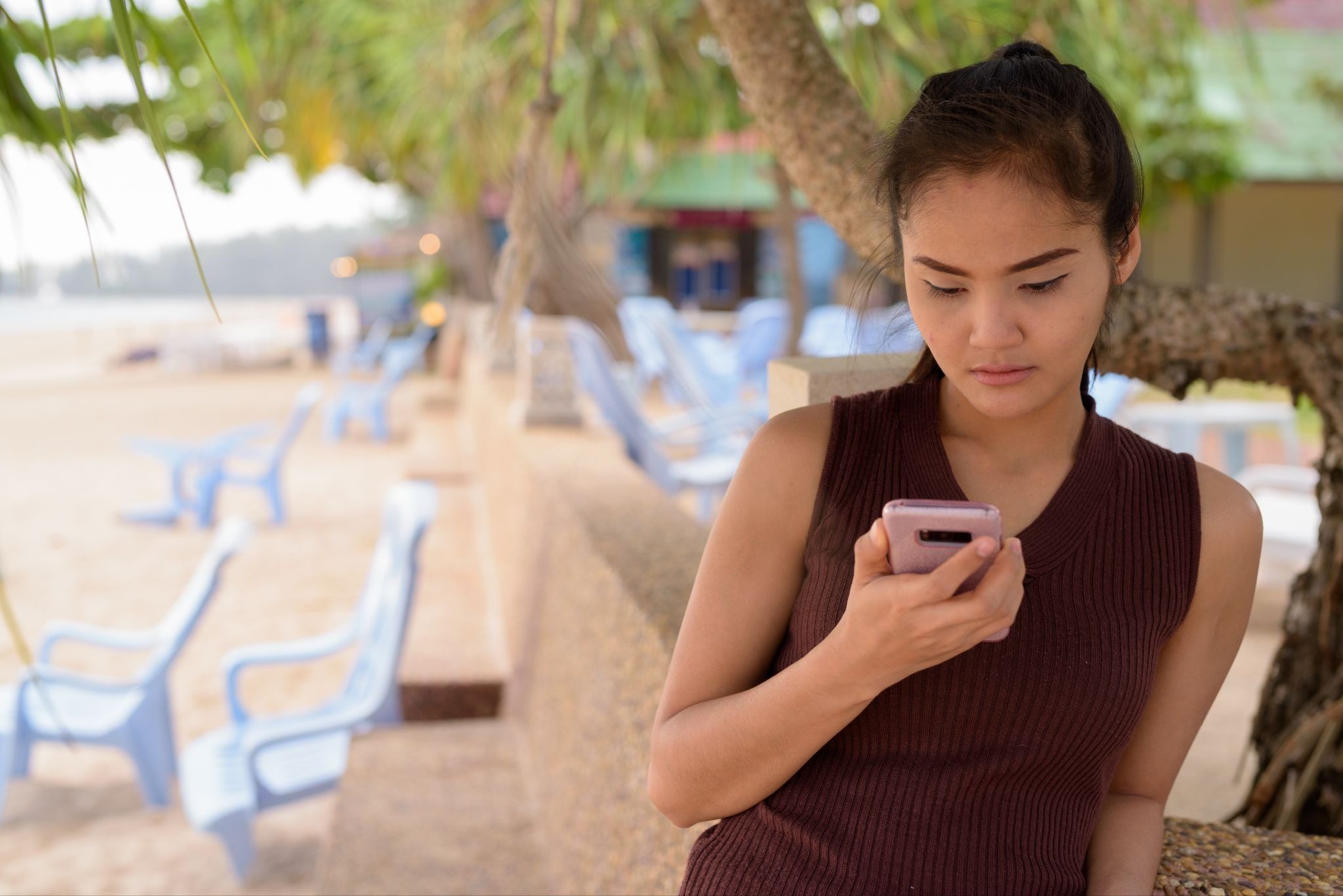 Японка с ухоженной кожей и макияжем смотрит в камеру телефона