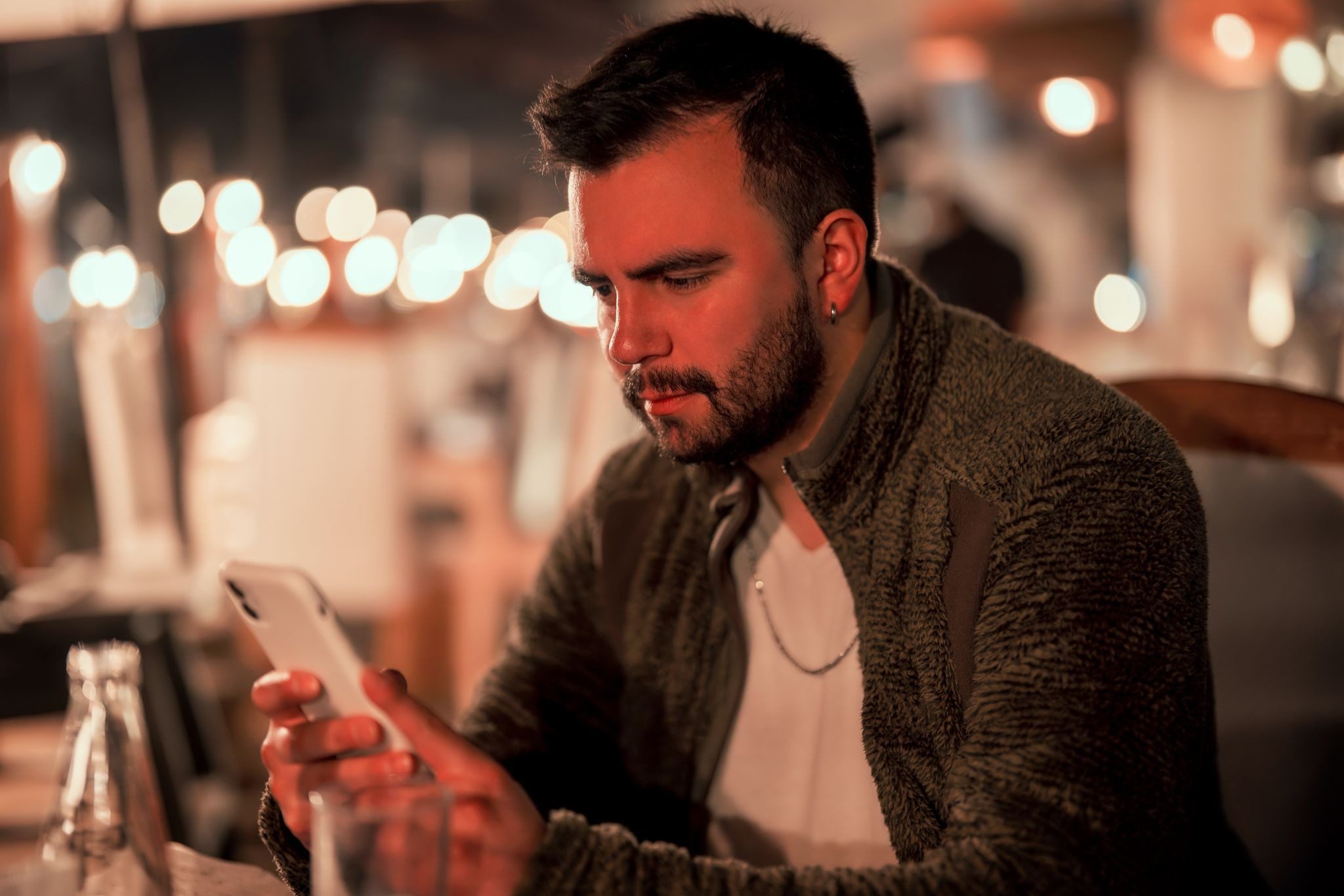 Парень читает первое сообщение от девушки ВКонтакте и улыбается