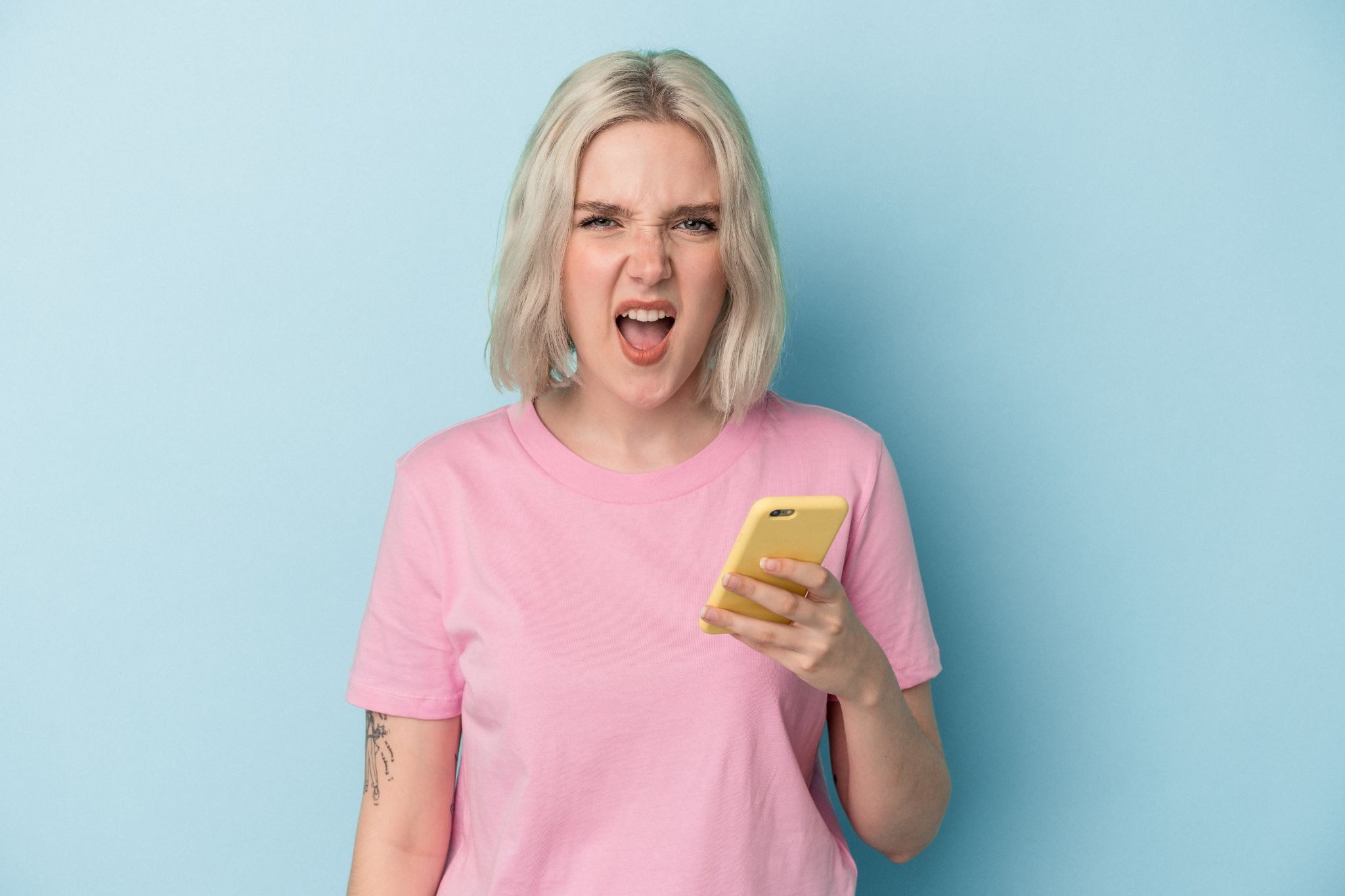 Девушка смеётся от забавного сообщения парня в мессенджере за чашкой кофе