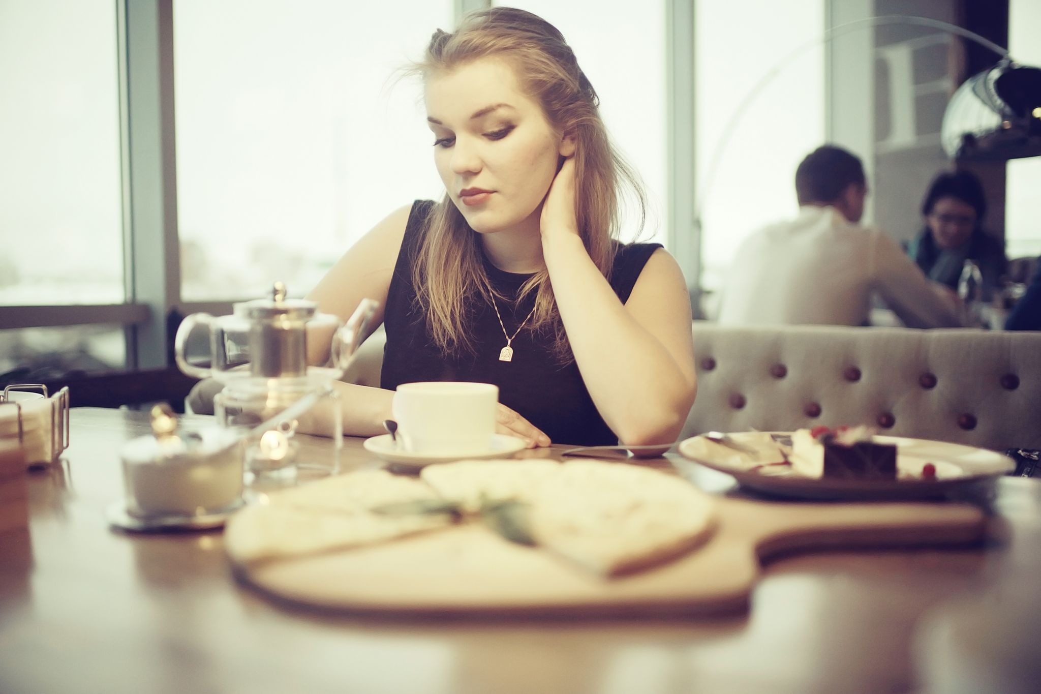девушка сидbт за столиком в кафе на первом свидании