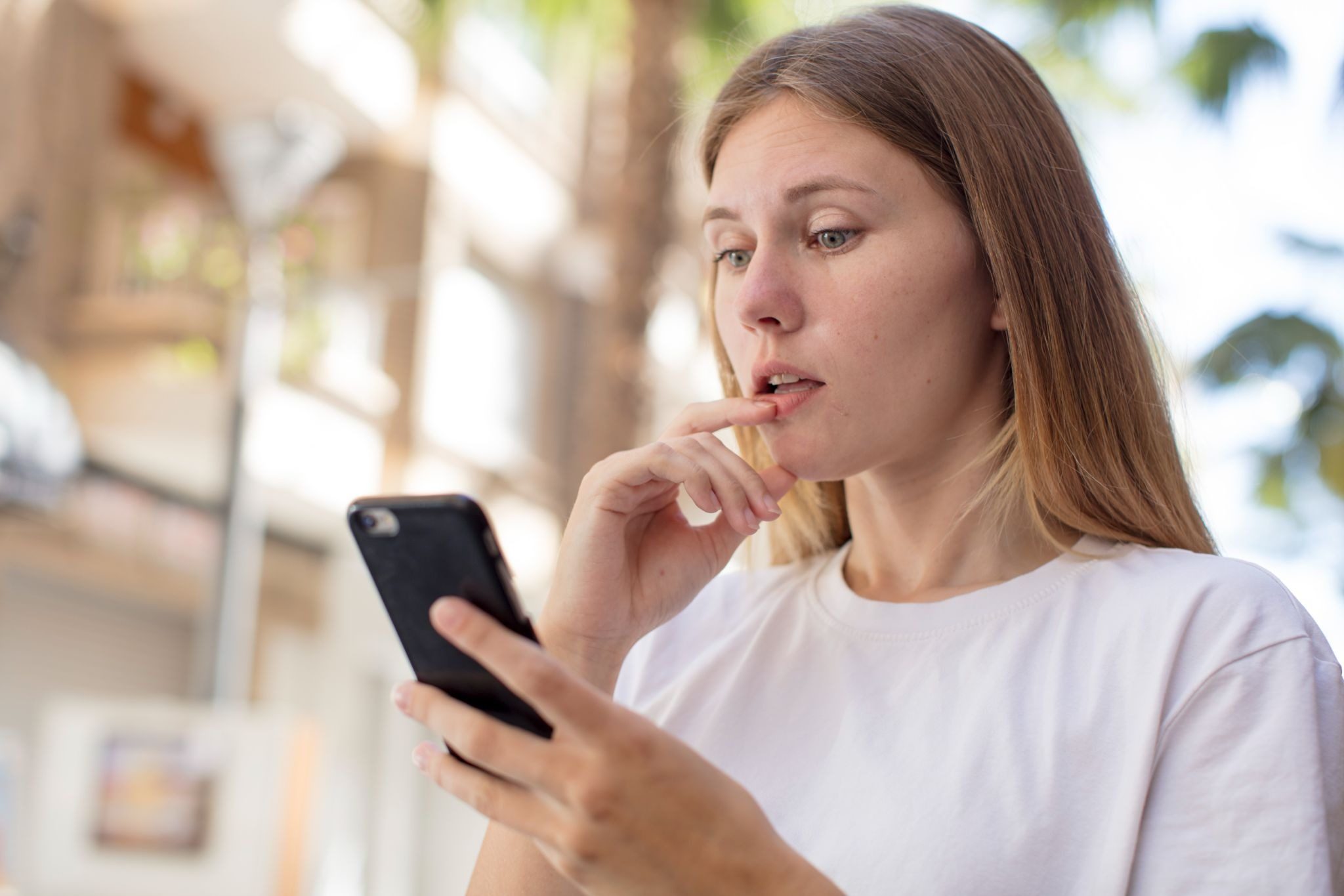 Девушка с улыбкой набирает цепляющее сообщение мужчине на телефоне