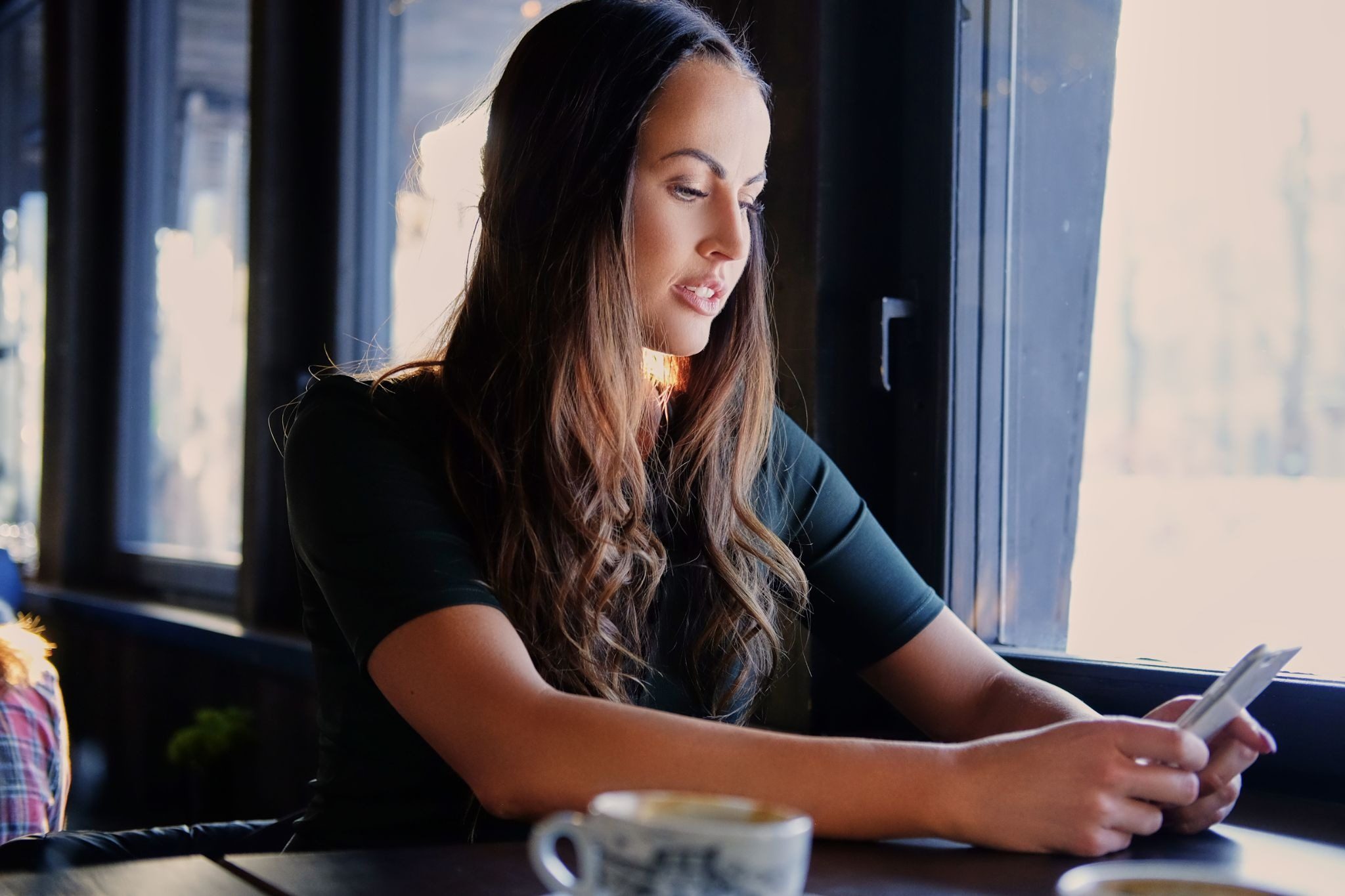 Девушка думает что написать парню и держит телефон