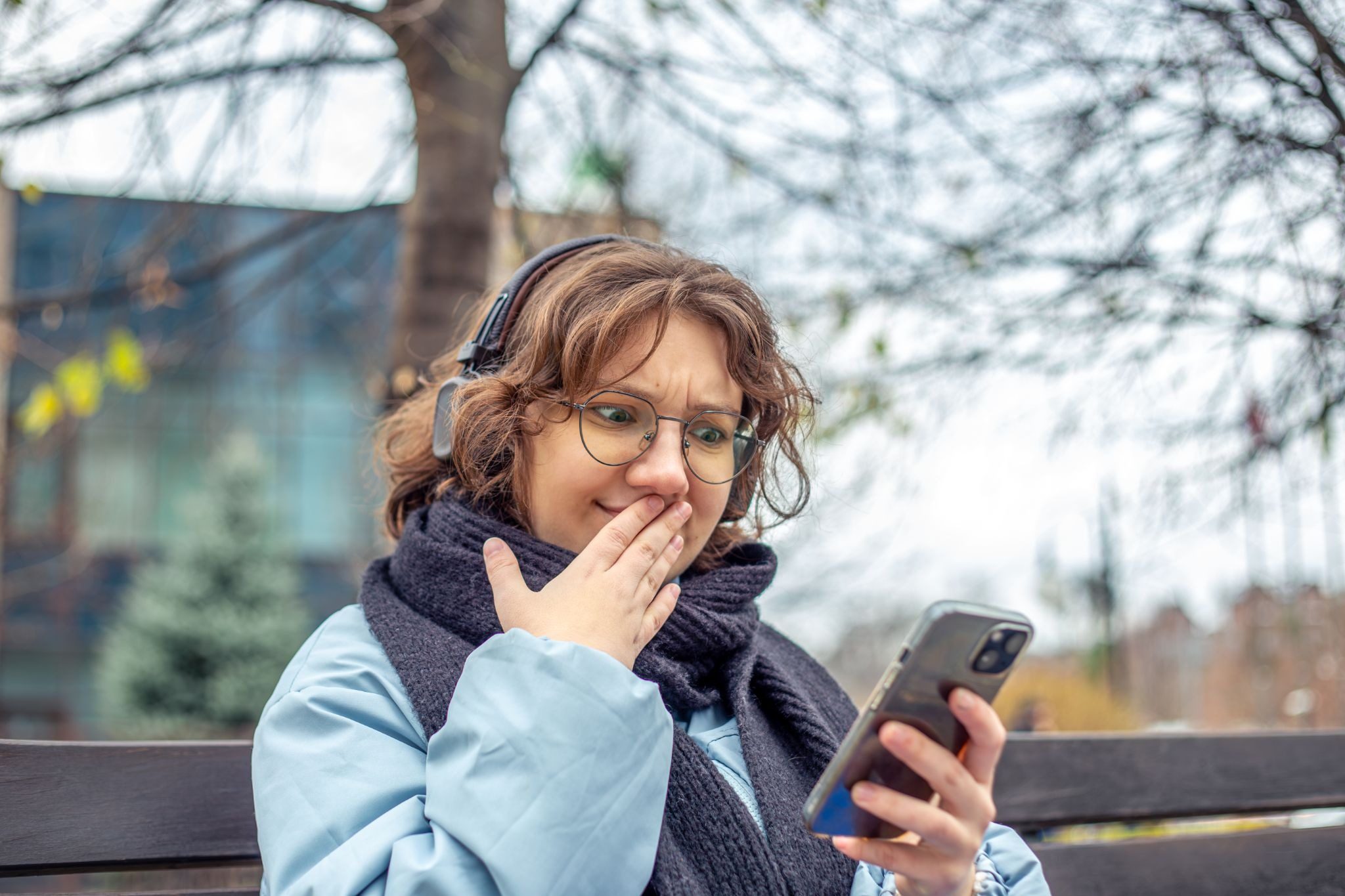 Девушка улыбается читая необычное первое сообщение от парня в Тиндере