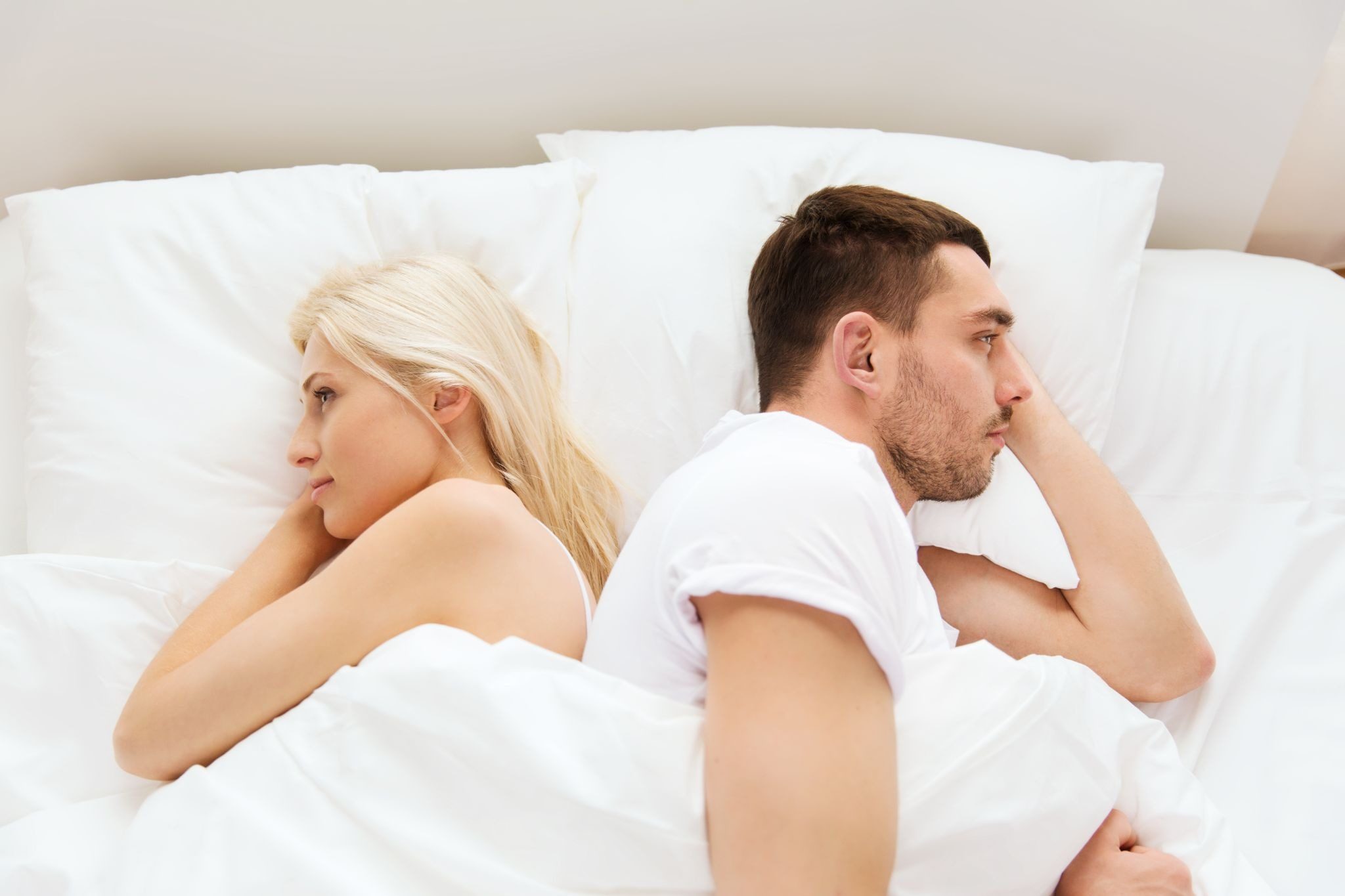 пара лежит в постели спиной друг к другу без контакта