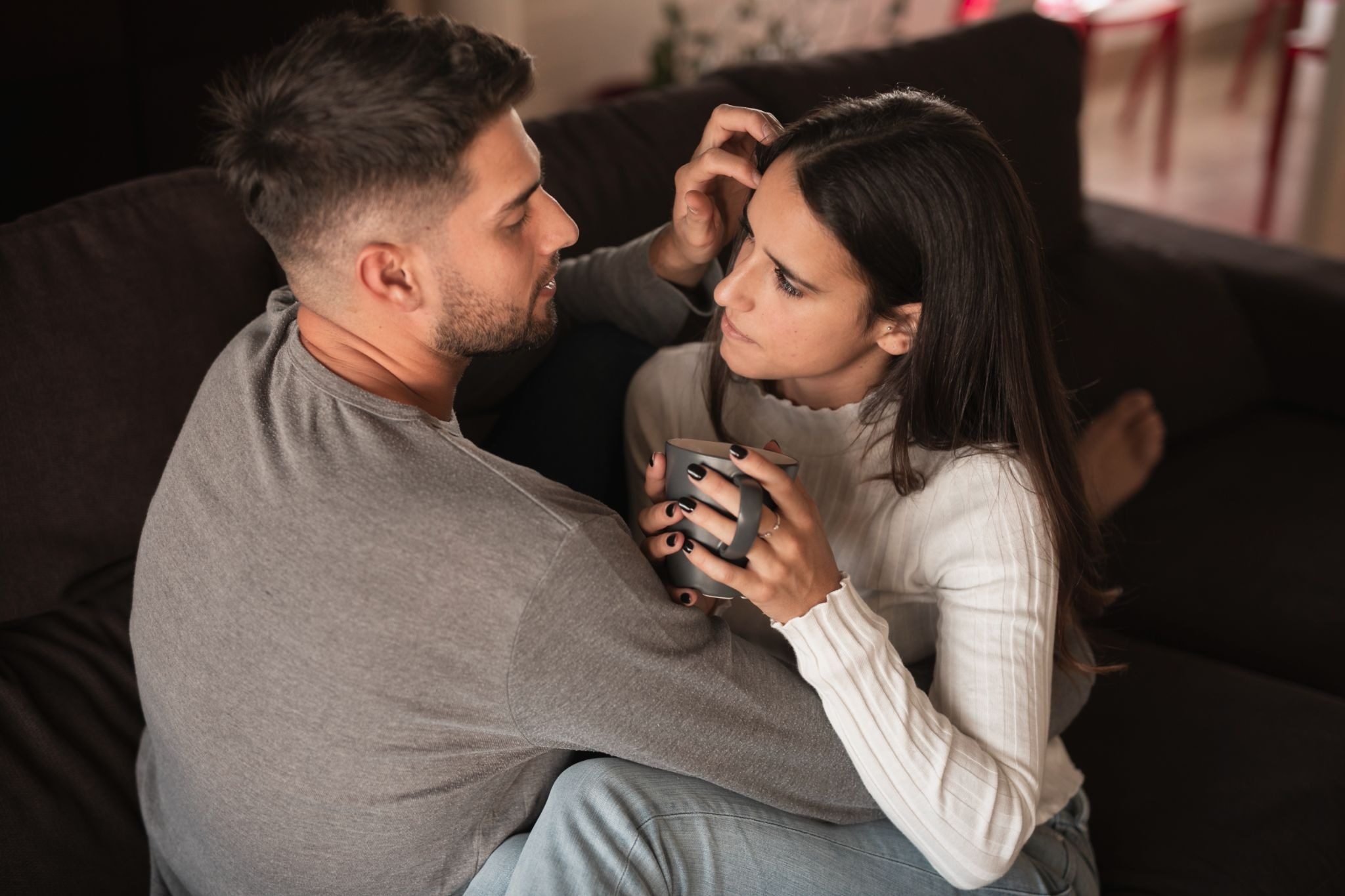 Девушка делает легкие прикосновения к руке мужчины