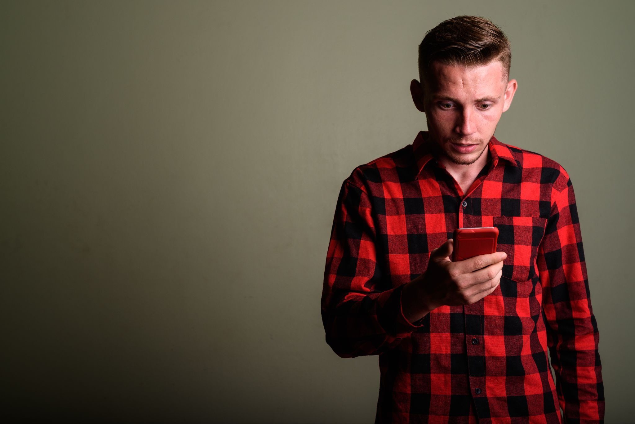 Мужчина листает анкеты в приложении и не решается написать