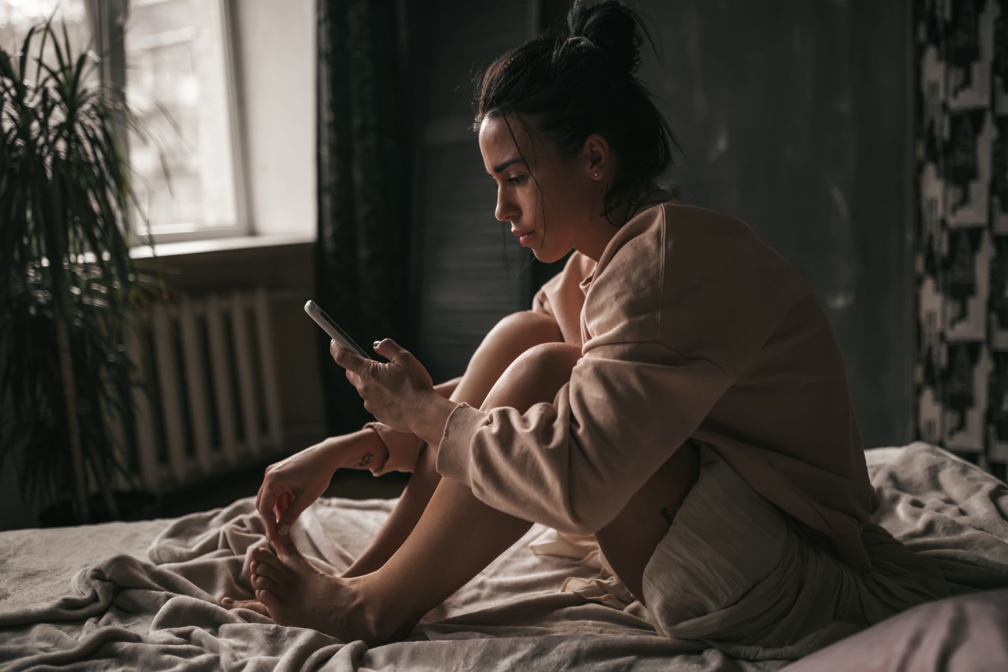 Женщина просматривает анкеты на сайте знакомств в смартфоне